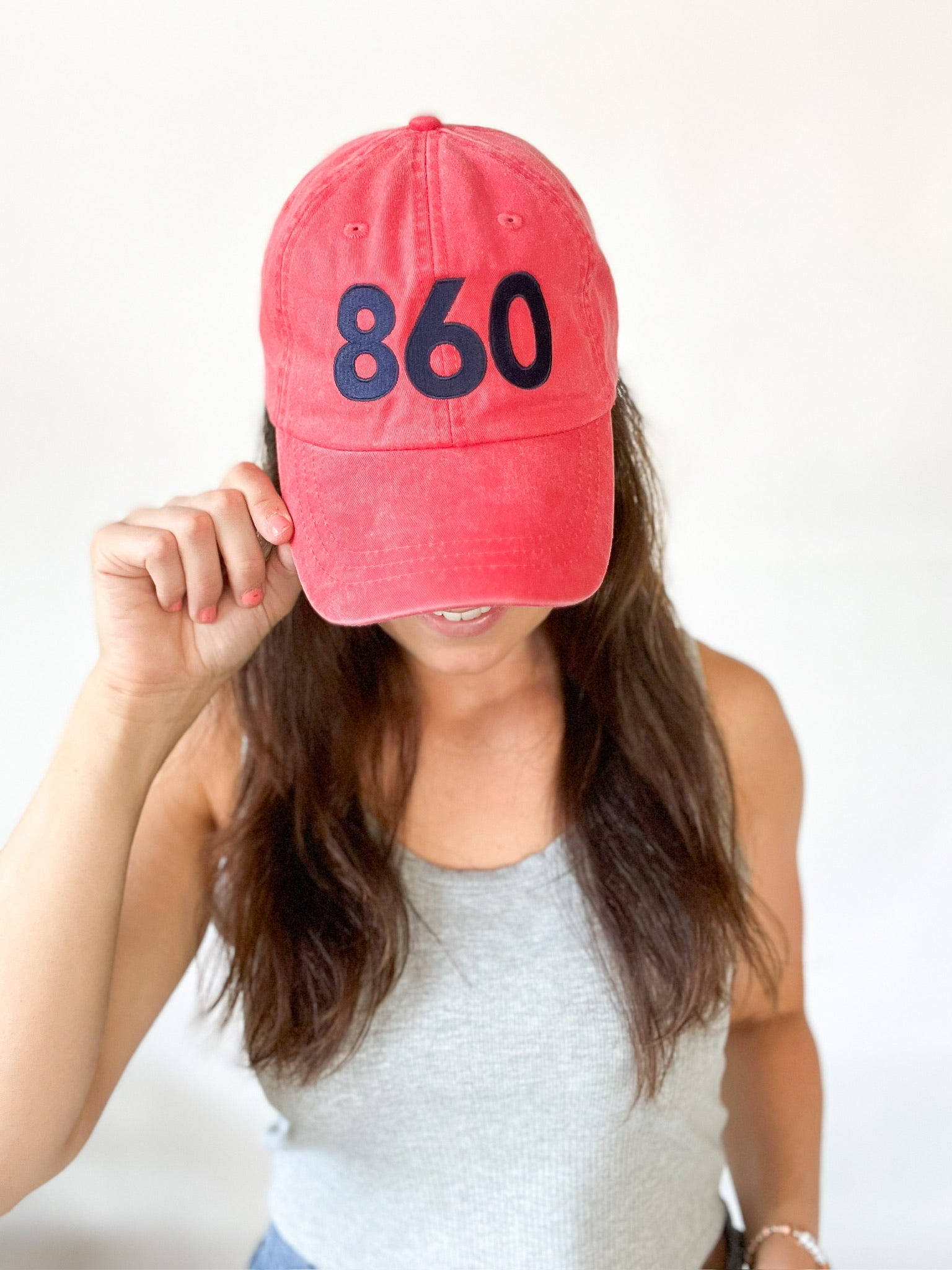 Red baseball cap with navy 860 embroidered on the front, Anchored American embroidered on the back, leather adjustment strap on the back