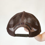 camo trucker hat with black 860 embroidered on the front, black Anchored American embroidered on the back