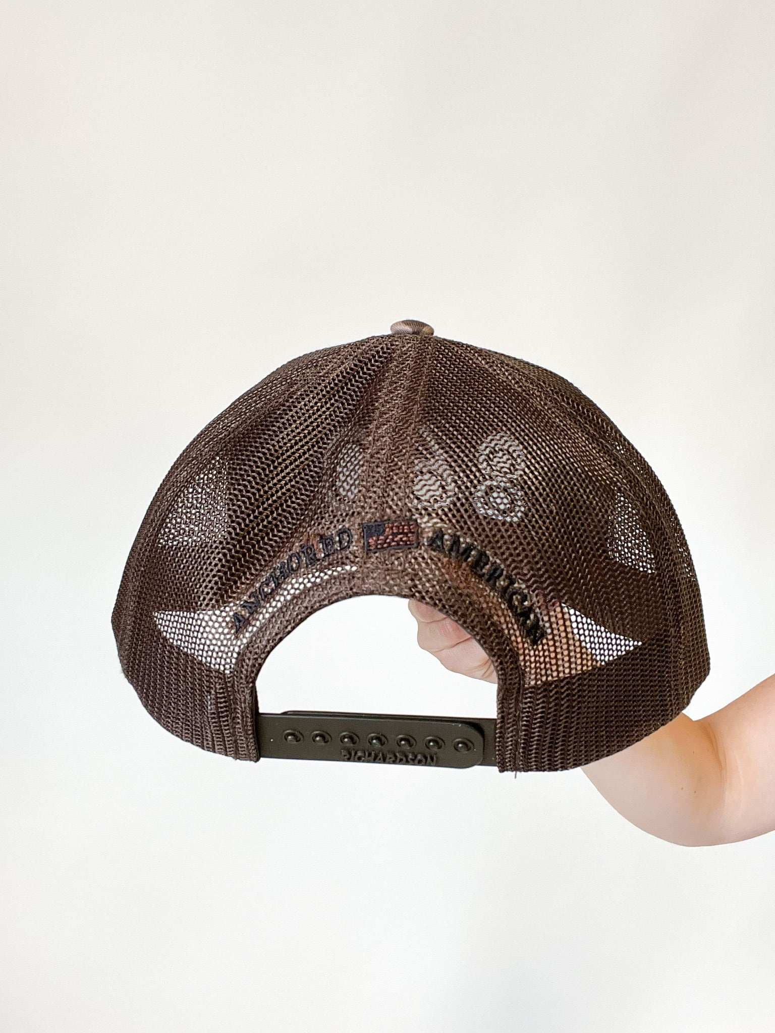 camo trucker hat with black 860 embroidered on the front, black Anchored American embroidered on the back