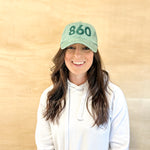 Green baseball cap with green 860 embroidered on the front, and a green anchored American embroidered on the back.