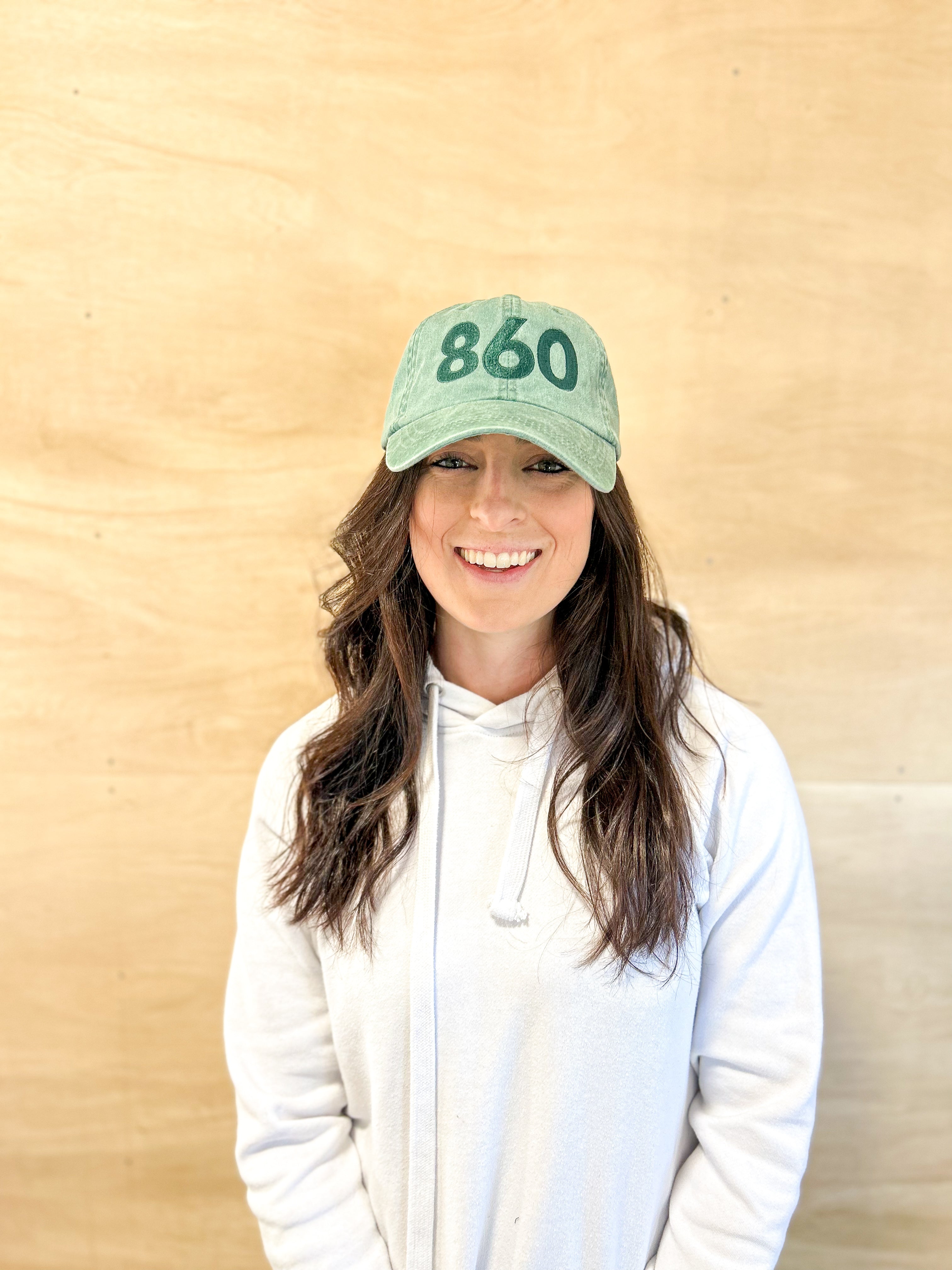 Green baseball cap with green 860 embroidered on the front, and a green anchored American embroidered on the back. 