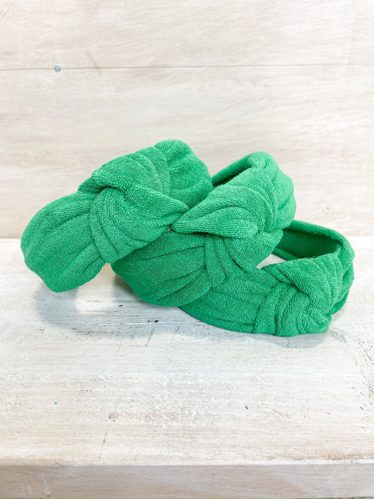 green terry cloth material, knot on the top of the headband, one size