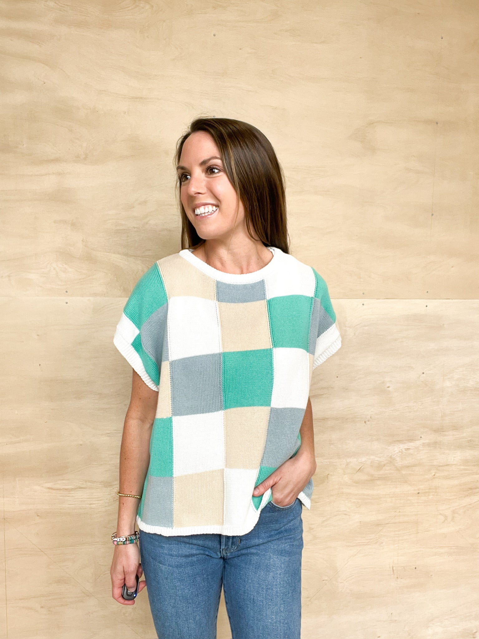 Short sleeve lightweight sweater, checkered detail featuring tan, grey, and teal squares, oversized fit, soft material