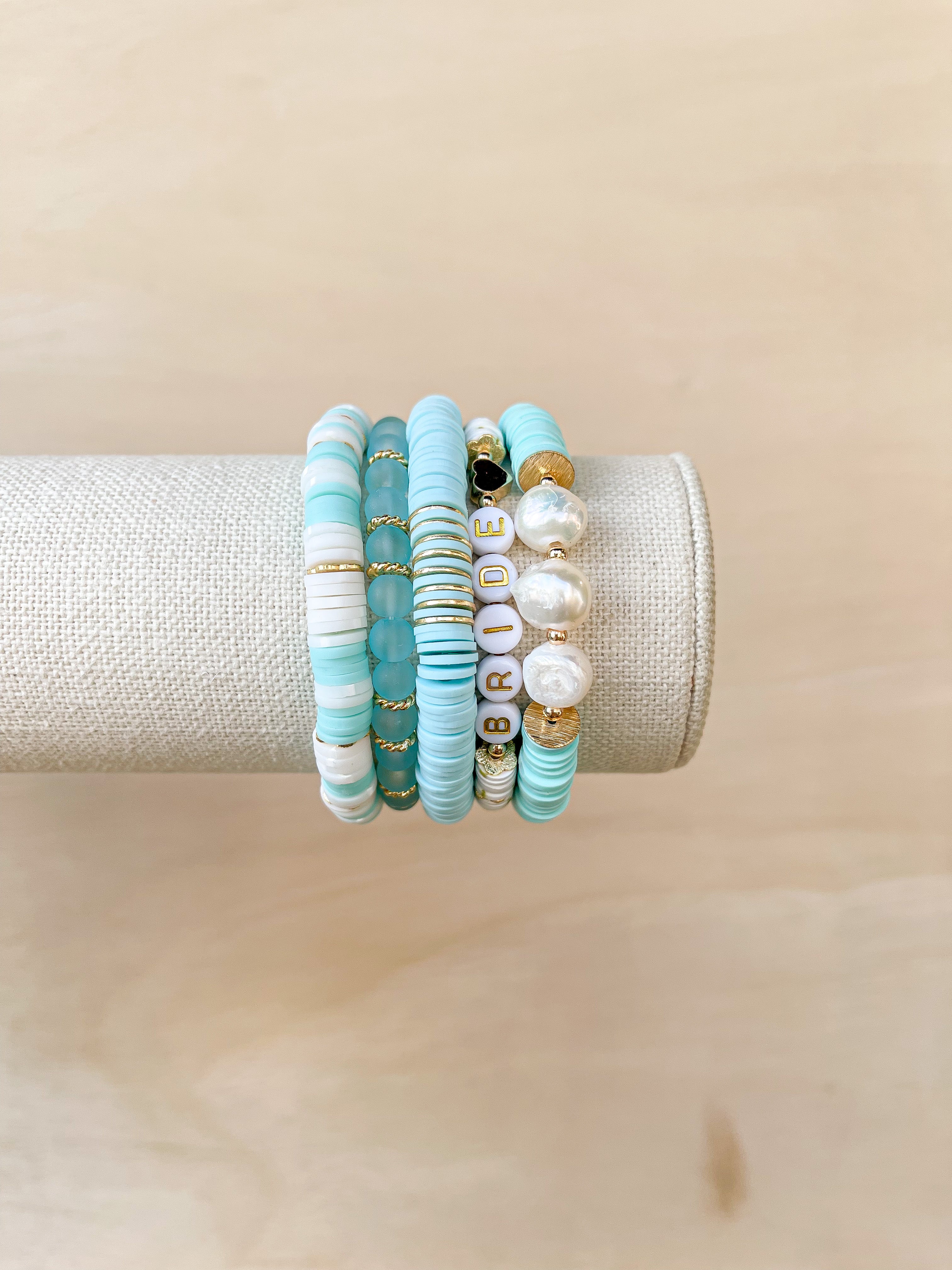 Handmade bracelet, locally made, soft clay bead, stretch bracelet, teal, white beads, paired with some other Callie favorite bracelets