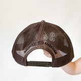 camo trucker hat with black 860 embroidered on the front, black Anchored American embroidered on the back