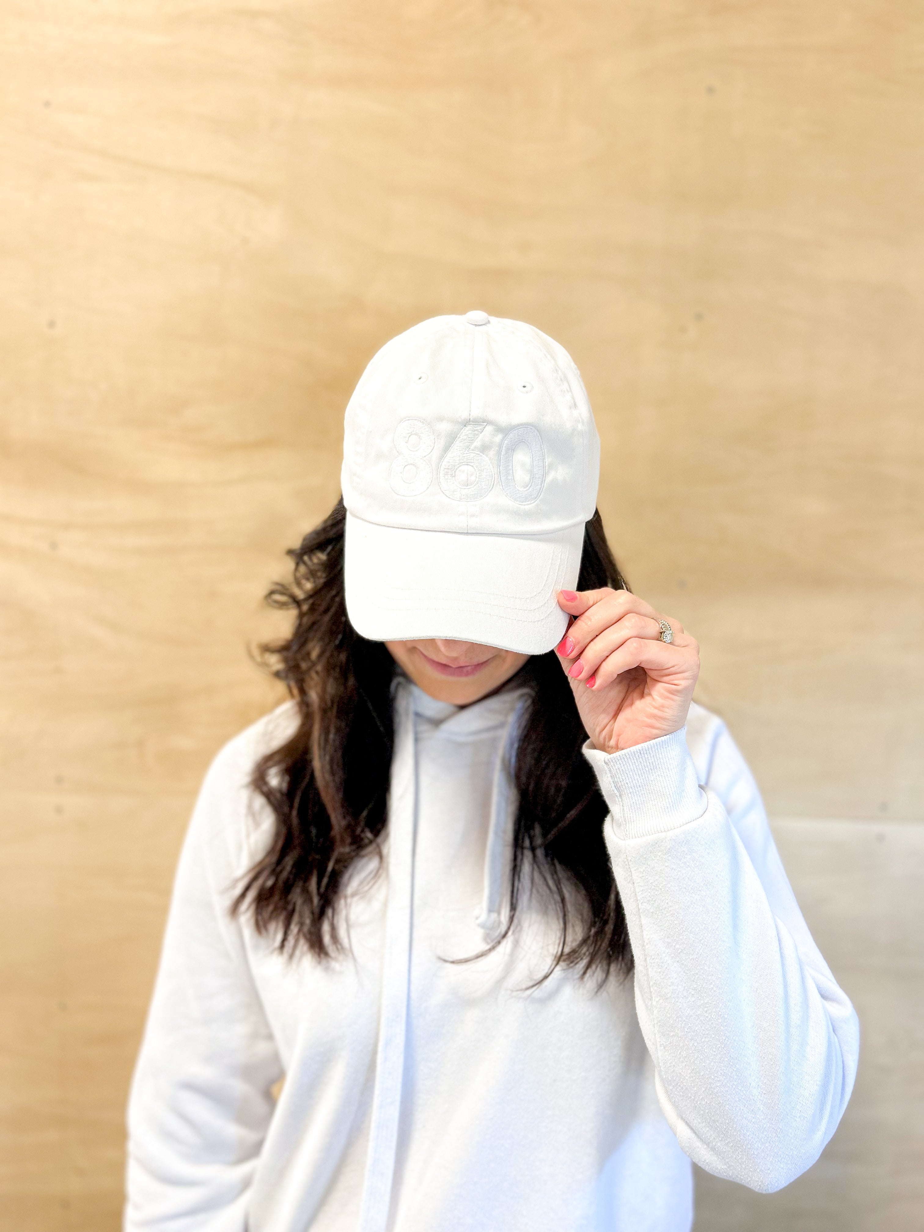 White baseball cap, white 860 embroidered on the front, white Anchored American on the back, leather adjusting strap