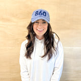 Blue baseball cap with blue 860 embroidered on the front, blue anchored american embroidered on the back leather adjustment strap