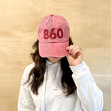 Red baseball cap, red 860 embroidered on the front, red Anchored American embroidered on the back, leather adjustment strap