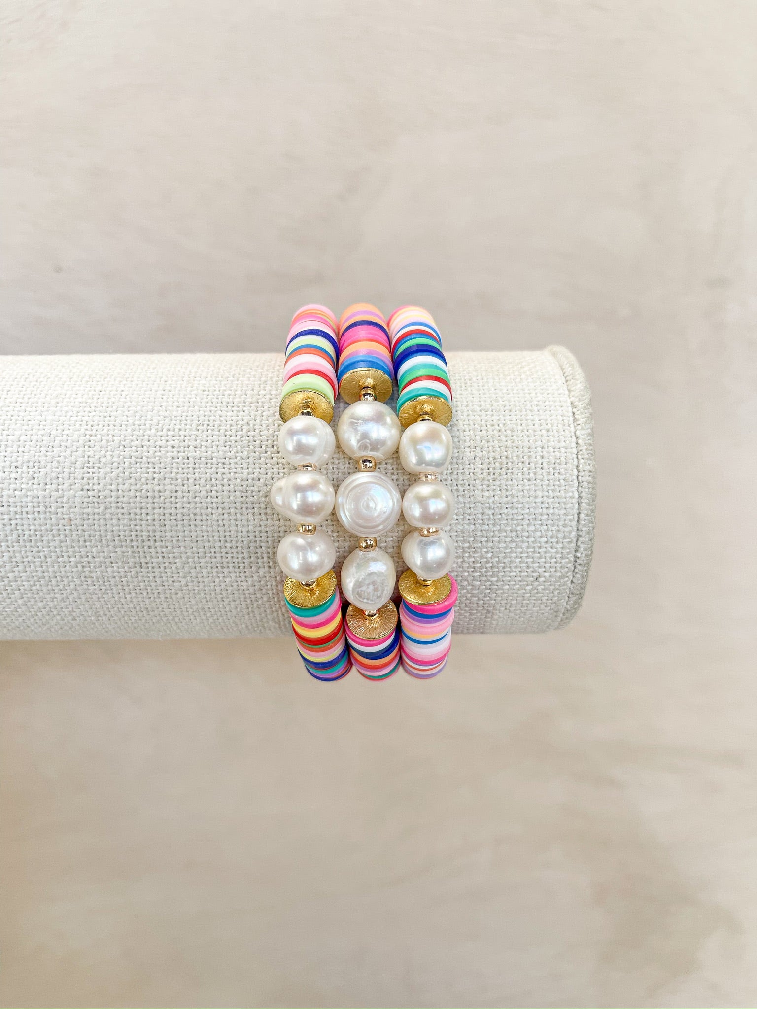 rainbow clay beads, gold spacers, with three pearls in the center, stretch bracelet