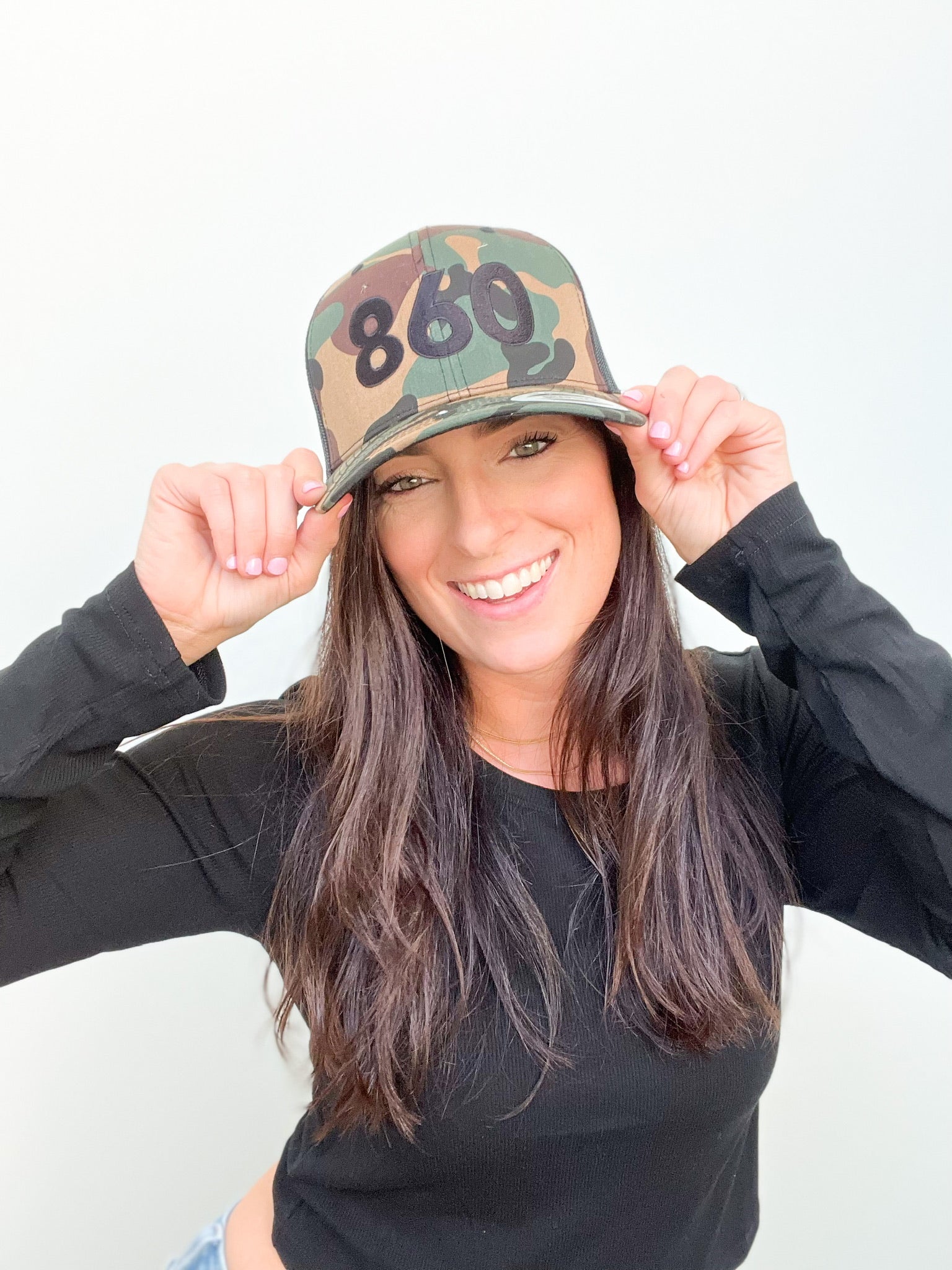 camo trucker hat with black 860 embroidered on the front, black Anchored American embroidered on the back